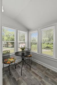 a living room with a table and chairs and windows at Spacious Cottage near Airport, Hospitals, and Highways in Bel-Ridge