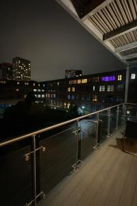 a balcony with a view of a city at night at The Central Suite in Manchester