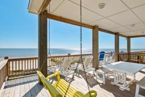a porch with a swing and a table and chairs at Deja Blue home in Caplen