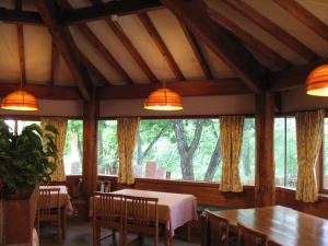 a dining room with tables and a large window at Pension Noel in Kaminoyama