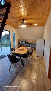 a dining room with a table and chairs in a kitchen at Cabaña Alpina Zen in Carmen del Paraná
