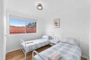 Erowal BayにあるThe Pearl A Fresh, Modern Family Retreat in Old Erowal Bayの窓のある部屋にベッドが2つある