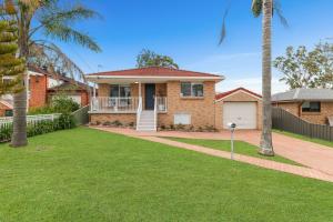 Erowal BayにあるThe Pearl A Fresh, Modern Family Retreat in Old Erowal Bayの椰子の木が植わる庭のあるレンガ造りの家