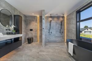 a bathroom with a shower and a sink at Luxury Beach Retreat - Mountain Views & Boat Jetty in Whitianga +28 photos