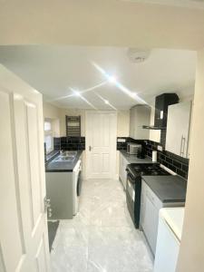 Kuchyň nebo kuchyňský kout v ubytování Modern 4-Bed Home Near Hospital & Station