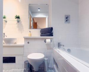 a bathroom with a toilet and a sink and a tub at The Central Suite in Manchester +13 photos