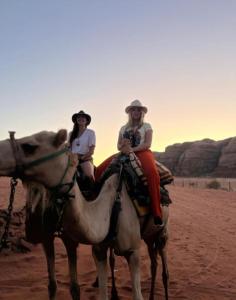 two people riding on a camel in the desert at Wadirum Leen camp in Wadi Rum +48 photos