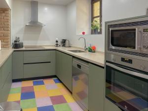 a kitchen with a sink and a microwave at Villa Rural La Torre by Hacienda Alfacara in Benadalid