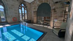 a bathroom with a large swimming pool in a building at Glenwood Apartment at The Highland Club in Fort Augustus