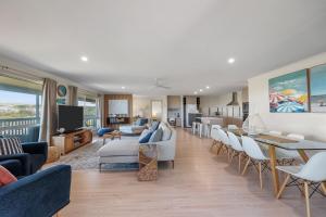 101 Padman Crs, Middleton في ميدلتون: غرفة معيشة بأثاث أبيض وغرفة طعام