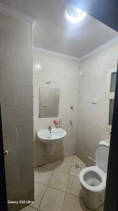 a bathroom with a toilet and a sink at Pyramids Porto Sokhna Hotel Apartments in Ain Sokhna