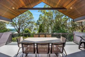 a patio with a table and chairs on a balcony at Amazing Views - Belle Escapes Jervis Bay in Vincentia
