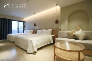 una habitación de hotel con dos camas y un sofá en Hotel Initial-Tainan, en Tainan 99 fotos más