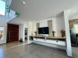 a living room with a flat screen tv on a wall at Mansão Maretti in Bertioga