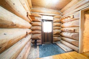 a log cabin hallway with a door and a window at Terrace Niseko Glide in Kutchan