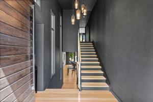 a staircase in a house with black walls and wooden floors at Romantic Lakefront Luxury - Spa Bath, Fireplace, King Bed in Daylesford +33 photos