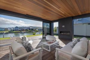 a living room with a couch and chairs and a fireplace at Luxury Beach Retreat - Mountain Views & Boat Jetty in Whitianga
