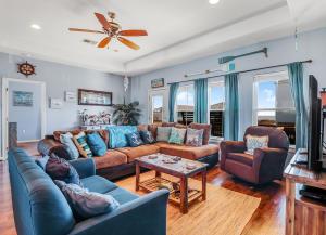 un salon avec un canapé bleu et des chaises dans l'établissement After Dune Delight Home, à Stingaree