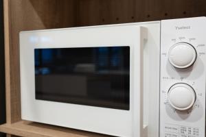 a white microwave oven with two knobs on it at Terrace Niseko Glide in Kutchan +60 photos