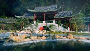 a building with a pool of water in front at Holiday Inn Guangzhou South Lake-an lHG Hotel in Guangzhou