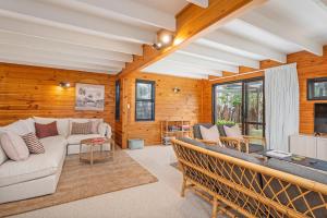 a living room with a couch and a table at Hosts on the Coast Hahei Sands Villa A in Hahei