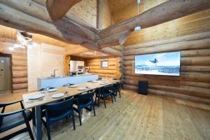 a dining room with wooden walls and tables and chairs at Terrace Niseko Glide in Kutchan