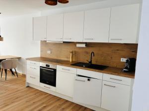 Una cocina blanca con gabinetes blancos y un fregadero. en Neue Ferienwohnung Bad Dürrheim Kurgebiet, Neue 3 Zimmer Wohnung Kurgebiet, en Bad Dürrheim 8 fotos más