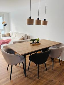 Un comedor con mesa y sillas de madera. en Neue Ferienwohnung Bad Dürrheim Kurgebiet, Neue 3 Zimmer Wohnung Kurgebiet, en Bad Dürrheim
