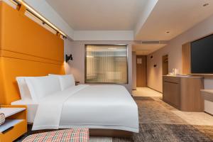 Postel nebo postele na pokoji v ubytování Yichang Shuaifu Platinum Hotel