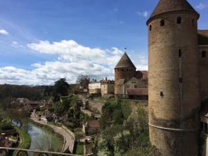un castillo con dos torres y un río en La Maison Févret en Semur-en-Auxois