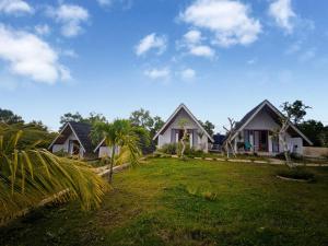 a house with a palm tree in front of it at The Bluhu Hill Cottage in Nusa Penida