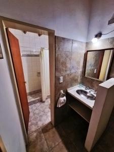 a bathroom with a sink and a mirror and a shower at Cabañas Lorelei in Villa General Belgrano