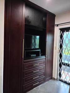 Vanilla Lee Corporate Suite في خليج ريتشاردز: مركز ترفيهي خشبي كبير مع تلفزيون بشاشة مسطحة