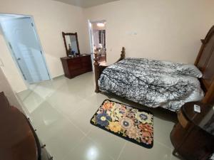 1 dormitorio con 2 camas, espejo y alfombra en Casa amarilla, en La Romana 2 fotos más