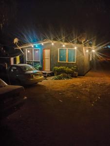 uma casa com um carro estacionado na frente dela à noite em Cabaña Entre eucaliptos em El Tabo