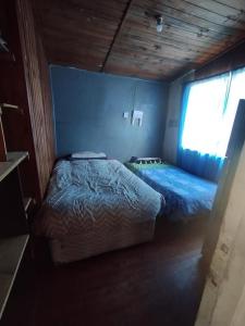 um quarto com uma cama em um quarto com janela em Cabaña Entre eucaliptos em El Tabo