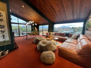 ワナカにあるPoolside Peaks - designer house, spa, fire, poolのソファと椅子とテーブルのあるリビングルーム