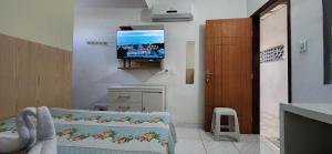 a room with a tv on the wall and a bed at Residencial dos Ipês in Itacaré