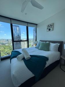 a bedroom with a large bed with large windows at Once Upon a View with Balcony Pool and Parking Level 33 in Brisbane +23 photos