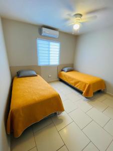 Ramos ArizpeCasa Recién-Remodelada Ideal, Ejecutivos, Trabajos的配有黄色床单的客房内的两张床