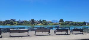 a group of benches sitting in front of a lake at Casa en el centro de llanquihue, hasta 10 personas in Llanquihue