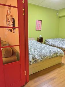 a room with two beds and a red door at The FLOW HOUSE in Suwon