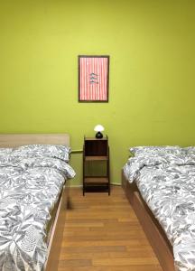 a room with two beds and a table with a picture at The FLOW HOUSE in Suwon