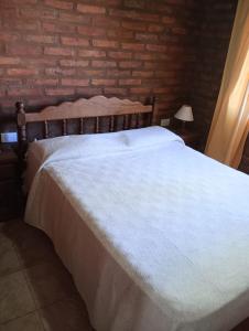 Posto letto in camera con muro di mattoni di Cabañas Yarel ad Alpa Corral