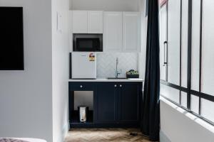 a kitchen with a blue cabinet and a microwave at Criterion Hotel Napier in Napier