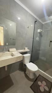a bathroom with a toilet and a sink and a shower at Pousada Atalaia in Cuiabá