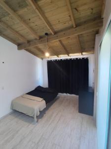 een slaapkamer met een bed en een zwart gordijn bij Loft em Florianópolis à 1km da praia in Florianópolis
