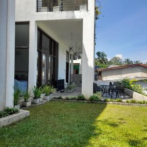 una casa blanca con césped delante en Pinnacle Life, en Matale 44 fotos más