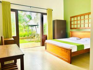 Un dormitorio con una cama y una puerta corrediza de vidrio. en Pinnacle Life, en Matale