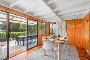 Hosts on the Coast Hahei Sands Villa B في هاهي: غرفة طعام بها طاولة وكراسي